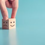 close-up-customer-hand-choose-smiley-face-and-sad-face-icon-on-wood-cube