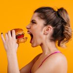 studio-shot-of-hungry-woman-with-sandwich