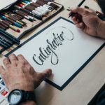 Hipster young illustrator artist does caligraphy